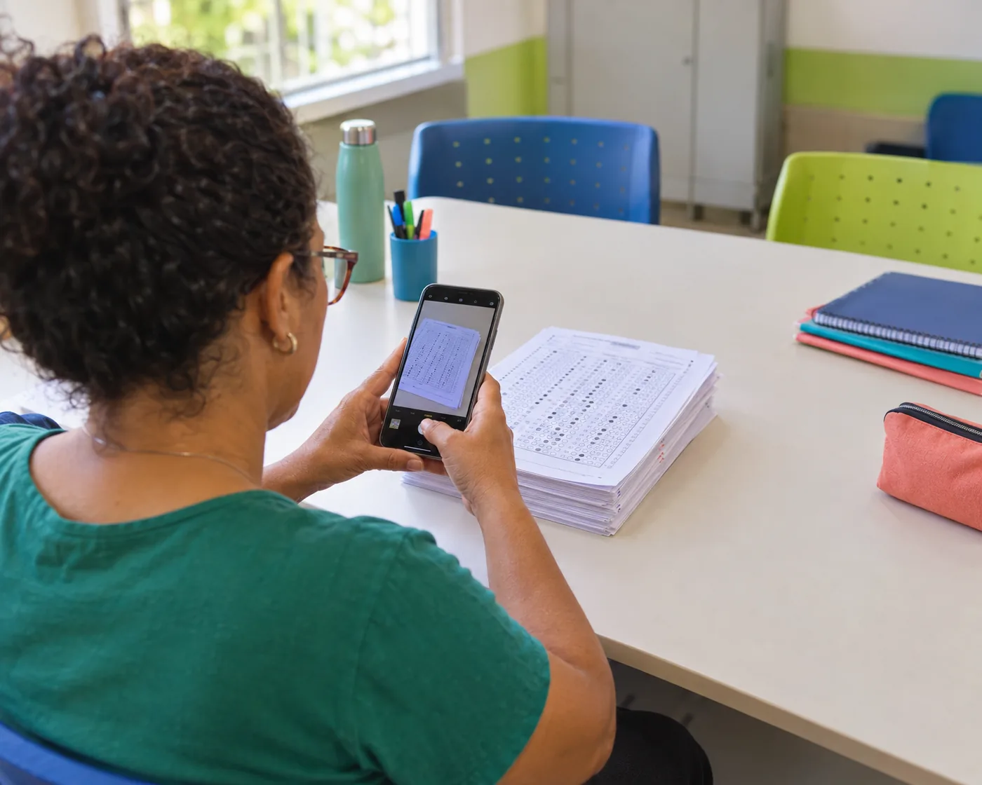 Professora fotografa cartões-resposta com o celular
